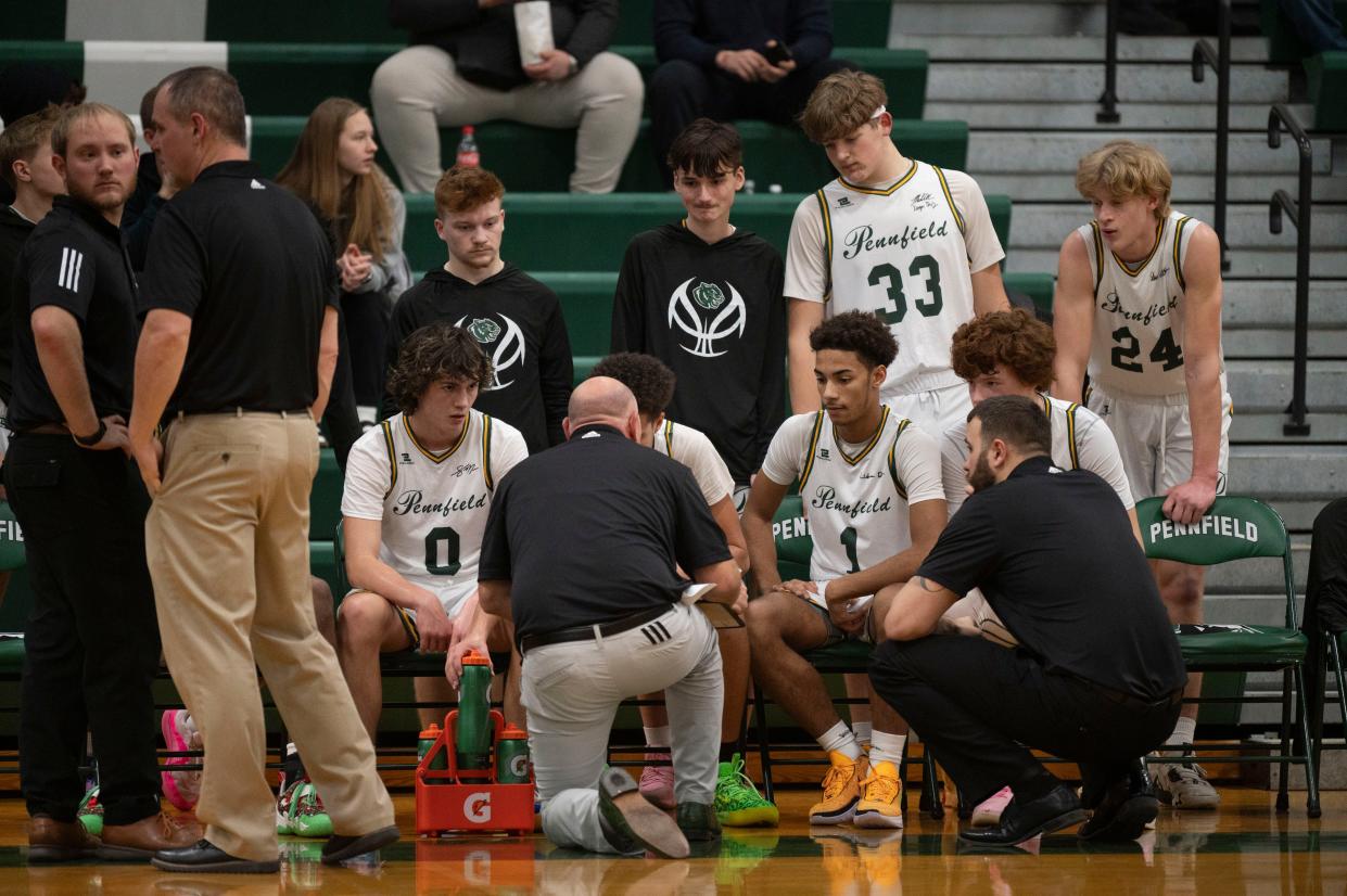 Pennfield players and coaching staff huddle up between quarters during a game against Harper Creek at Pennfield High School on Tuesday, Jan. 9, 2024.