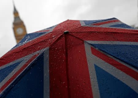 A Union Flag umbrella is seen in front of the Elizabeth Tower, commonly known as Big Ben, in London, Britain, August 9, 2017. REUTERS/Hannah McKay