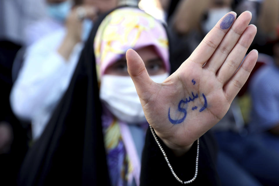 A supporter of presidential candidate Ebrahim Raisi shows her hand with writing in Persian that reads "Raisi", during a rally in Tehran, Iran, Wednesday, June 16, 2021. Iran's clerical vetting committee has allowed just seven candidates for the Friday, June 18, ballot, nixing prominent reformists and key allies of President Hassan Rouhani. The presumed front-runner has become Ebrahim Raisi, the country's hard-line judiciary chief who is closely aligned with Supreme Leader Ayatollah Ali Khamenei. (AP Photo/Ebrahim Noroozi)