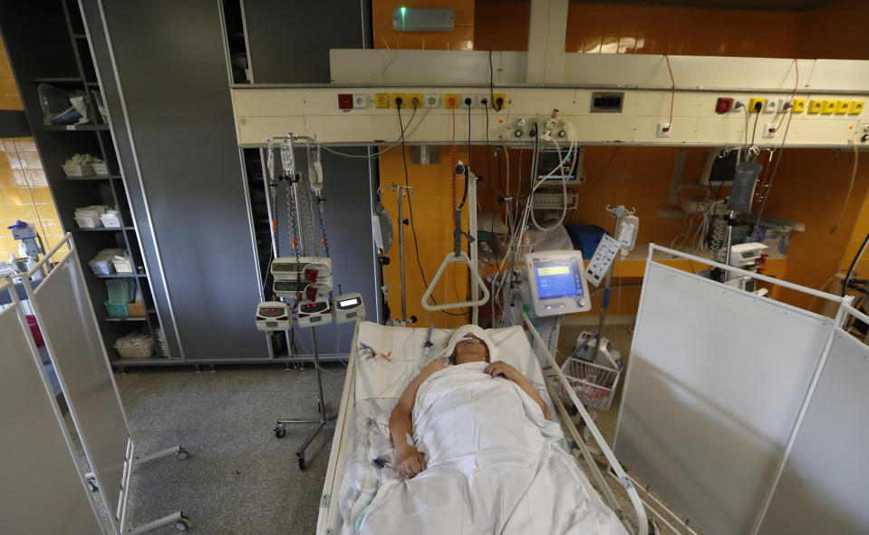 FILE - In this Oct. 1, 2020 file photo a COVID-19 patient lies on a bed in an intensive care unit (ICU) at Na Bulovce hospital in Prague, Czech Republic. Czechs had been assured it wouldn't happen again. But amid a record surge of coronavirus infections that's threatening the entire health system with collapse, the Czech Republic is adopting on Thursday exactly the same massive restrictions it slapped on citizens in the spring. Prime Minister Andrej Babis had repeatedly said these measures would never be repeated. (AP Photo/Petr David Josek, File)