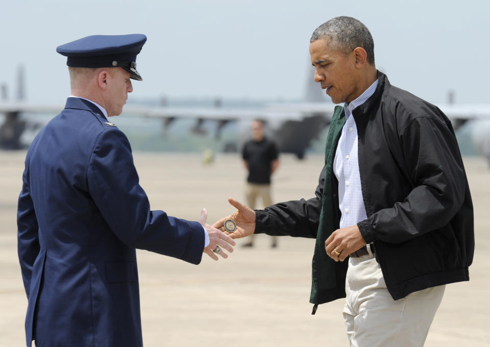 President Barack Obama shakes hands with Col. Patrick Rhatigan, Commander, 19th Airlift Wing & Little Rock AFB, left, and give him a challenge coin after Obama arrives at Little Rock Air Force Base, Ark., Wednesday, May 7, 2014. Obama is visiting with first responders and families affected by the recent tornados. (AP Photo/Susan Walsh)