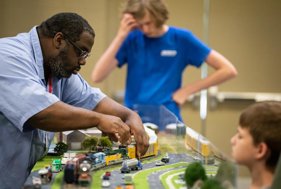 Austin Model Railway Society member Frankie Wright adjusts some trains on the track while working on the AMRS's model railroad, which depicts the historical railway in downtown Austin and the surrounding area at the Austin 2023 Train Show in the Palmer Events Center, May 6, 2023.