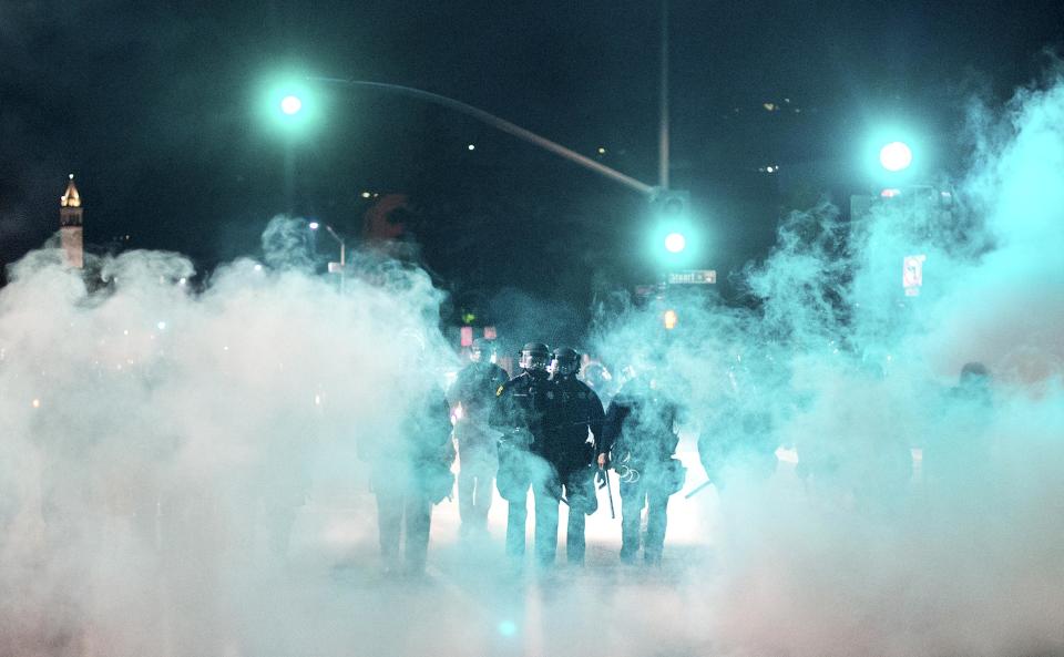 Police officers deploy teargas while trying to disperse a crowd comprised largely of student protesters during a protest against police violence in the U.S., in Berkeley