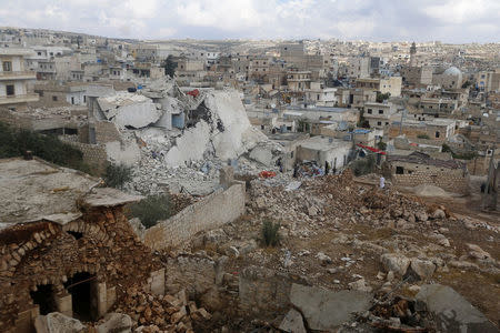 People inspect a site hit by what residents said were airstrikes carried out by the Russian air force in the town of Darat Izza in the province of Aleppo, October 7, 2015. REUTERS/Ammar Abdullah