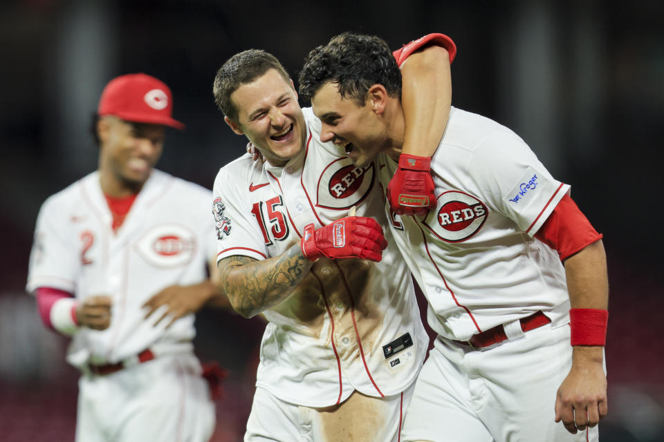 Cincinnati Reds' Nick Senzel, front left, celebrates with Luke Maile, right, after hitting a walkoff sacrifice fly during the 10th inning of a baseball game against the St. Louis Cardinals in Cincinnati, Monday, May 22, 2023. (AP Photo/Aaron Doster)