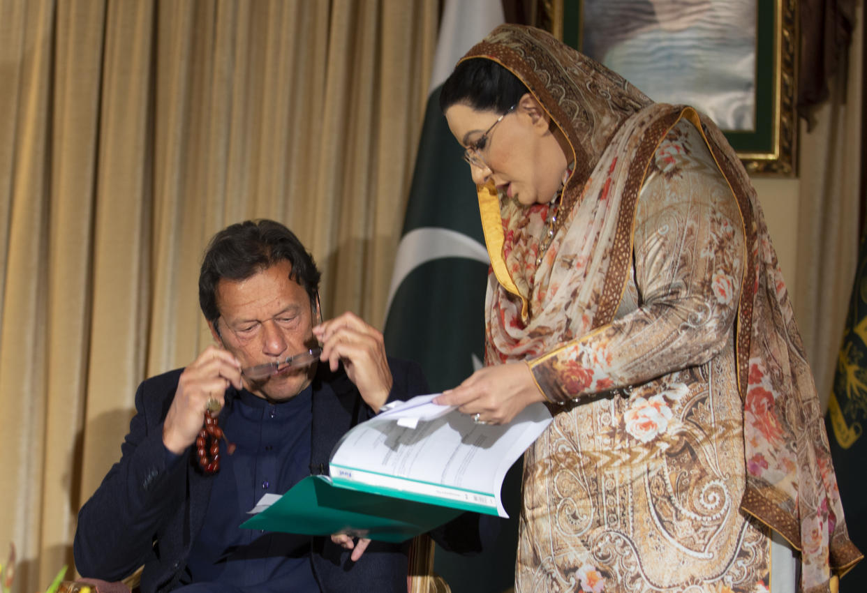 Pakistan government spokesperson Firdous Ashiq Awan consults with Pakistani Prime Minister Imran Khan in Islamabad (AP Photo/B.K. Bangash)