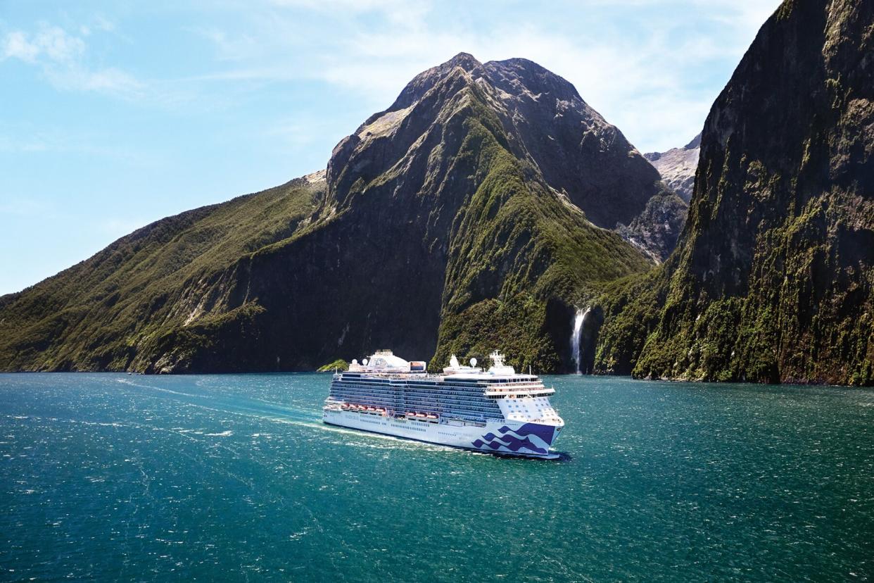 Aerial of the Majestic Princess sailing through a water fiord in Milford Sound, New Zealand