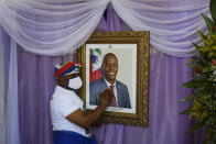 A man touches a portrait of the late Haitian President Jovenel Moïse outside the Cathedral where a memorial service for him takes place in Cap-Haitien, Haiti, Thursday, July 22, 2021. Moïse was killed in his home on July 7. (AP Photo/Matias Delacroix)