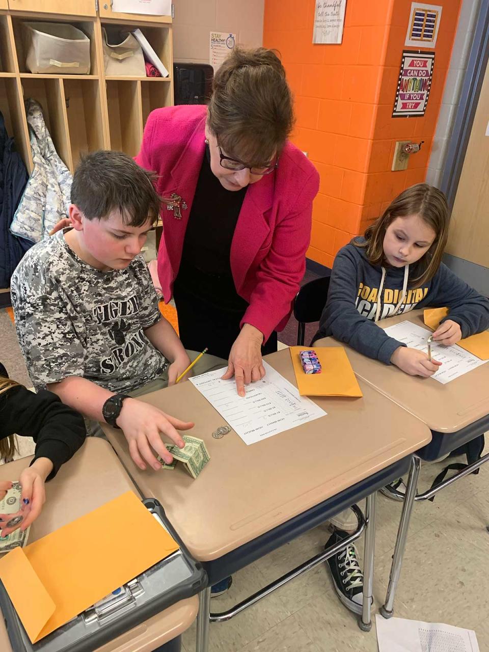 Galion City Schools Treasurer Charlene Parkinson, center, works with Wesley Williams, left, and Shanessa Bryant to count recently collected donations during the Galion Intermediate School's fundraiser benefiting the Galion Golden Age Center.