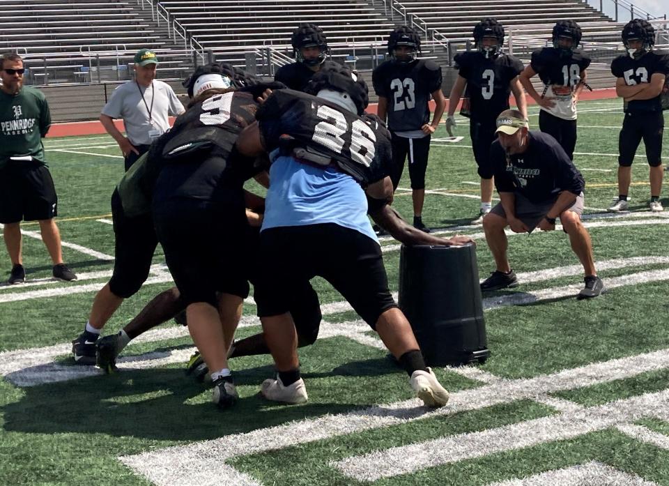 First-year Pennridge coach Kyle Beller (right of can) intently watches a practice drill.