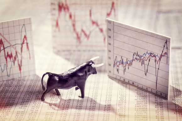 A figure of a bull surrounded by stock charts.