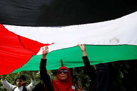 People hold up the Palestinian flag during a protest by Muslim groups to condemn Washington's decision to recognize Jerusalem as Israel's capital outside the U.S. embassy in Jakarta, Indonesia December 8, 2017. REUTERS/Darren Whiteside