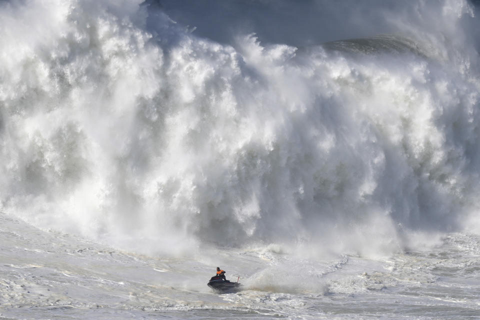 Una moto acuática se aleja de una ola rompiente durante una sesión de surf de olas colosales en Praia do Norte, en Nazare, Portugal, el 25 de febrero de 2022. (AP Foto/Armando Franca)