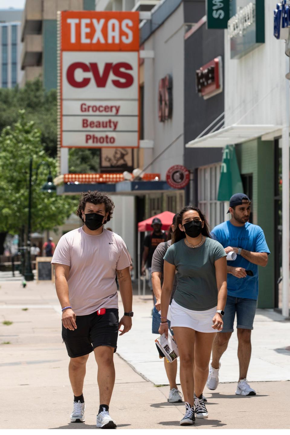 People wear masks as they walk along the Drag near the University of Texas in July 2021, during a surge in COVID-19 cases. Today, the CDC recommends wearing masks five days immediately after an infection.