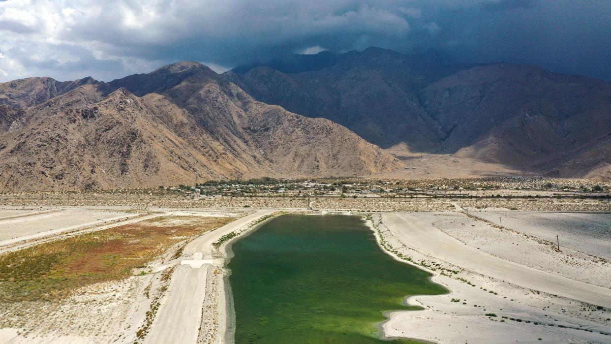 Water absorbs into the underground aquifer at one of the recharge ponds in Palm Springs, Calif., July 31, 2022.  This pond is near the Windy Point neighborhood which can be seen in the background below Mt. San Jacinto.