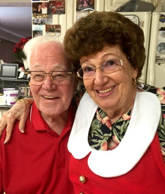 Janet Alessi's parents pose in red outfits for the holidays.
