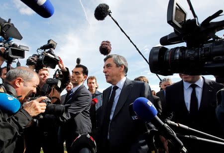 Francois Fillon (R), former French prime minister, member of the Republicans political party and 2017 presidential election candidate of the French centre-right walks in vineyards, surrounded by the media, after a meeting with winegrowers in Nimes, France, March 2, 2017. REUTERS/Jean-Paul Pelissier