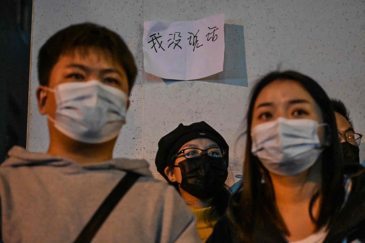 Protesters stand beneath a sign that reads, ‘I didn’t say anything’, in Shanghai on Sunday (AFP/Getty)