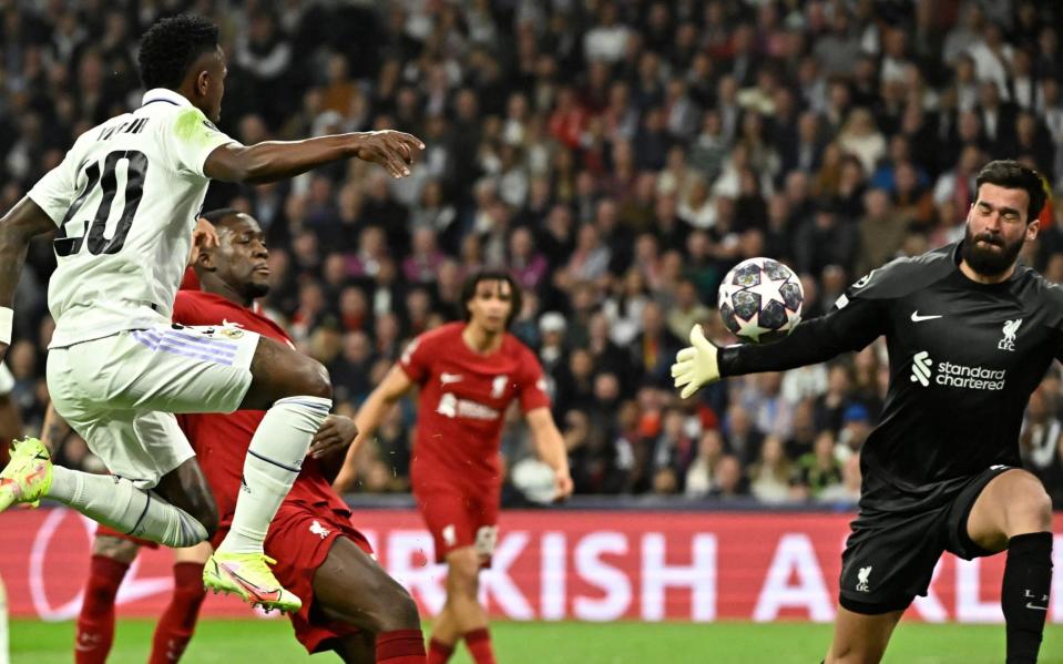 Liverpool's Brazilian goalkeeper Alisson Becker (R) saves Real Madrid's Brazilian forward Vinicius Junior - JAVIER SORIANO/AFP via Getty Images