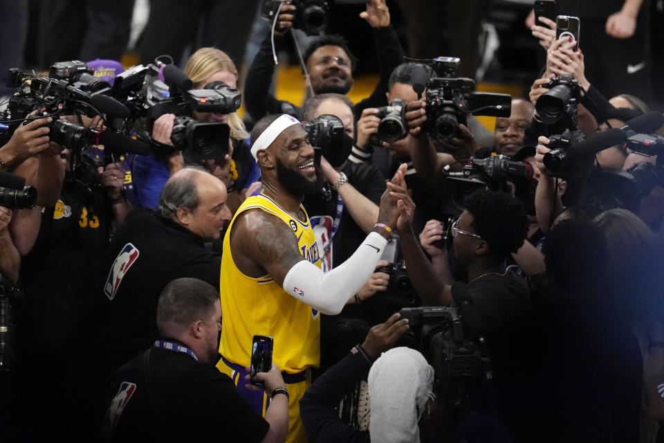 Los Angeles Lakers forward LeBron James is surrounded by cameras after scoring to pass Kareem Abdul-Jabbar to become the NBA's all-time leading scorer during the second half of an NBA basketball game against the Oklahoma City Thunder Tuesday, Feb. 7, 2023, in Los Angeles. (AP Photo/Marcio Jose Sanchez)