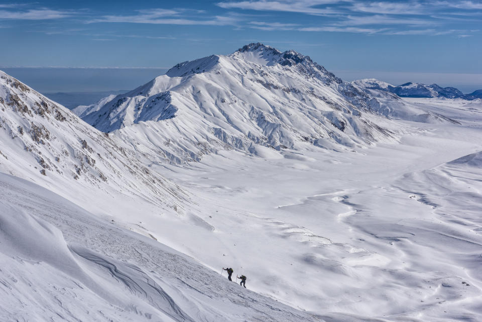 Italy, Abruzzo, Gran Sasso e Monti della Laga, Hikers on Campo Imperatore plateau in winter