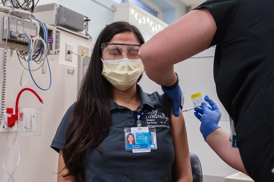 A healthcare worker gives the COVID-19 vaccine to Kassandra Martinez, an EVS Attendant and Lead, at Rady Children's Hospital in San Diego, California on December 15, 2020. (Photo: ARIANA DREHSLER AFP) 