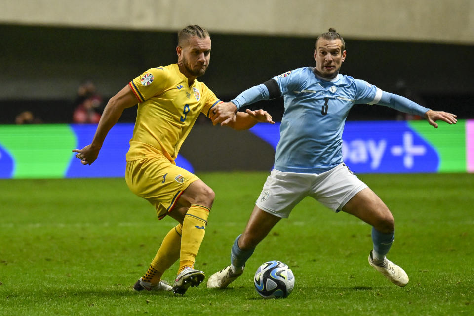 Israel's Shon Goldberg, right, duels for the ball with Romania's George Puscas during the Euro 2024 group I qualifying soccer match between Israel and Romania at the Pancho Arena in Felcsut, Hungary, Saturday, Nov. 18, 2023. (AP Photo/Denes Erdos)