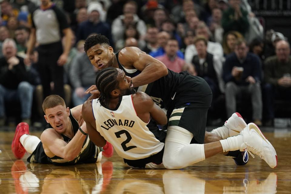 Milwaukee Bucks' Giannis Antetokounmpo and Donte DiVincenzo battle for a loose ball with Los Angeles Clippers' Kawhi Leonard (2) during the second half of an NBA basketball game Friday, Dec. 6, 2019, in Milwaukee. (AP Photo/Morry Gash)