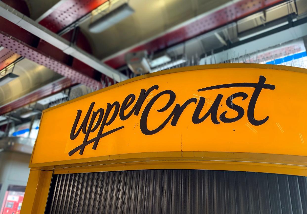 A logo is pictured above a closed-down and shuttered Upper Crust food outlet in a train station in London on July 1, 2020. Photo: DANIEL LEAL-OLIVAS/AFP via Getty Images