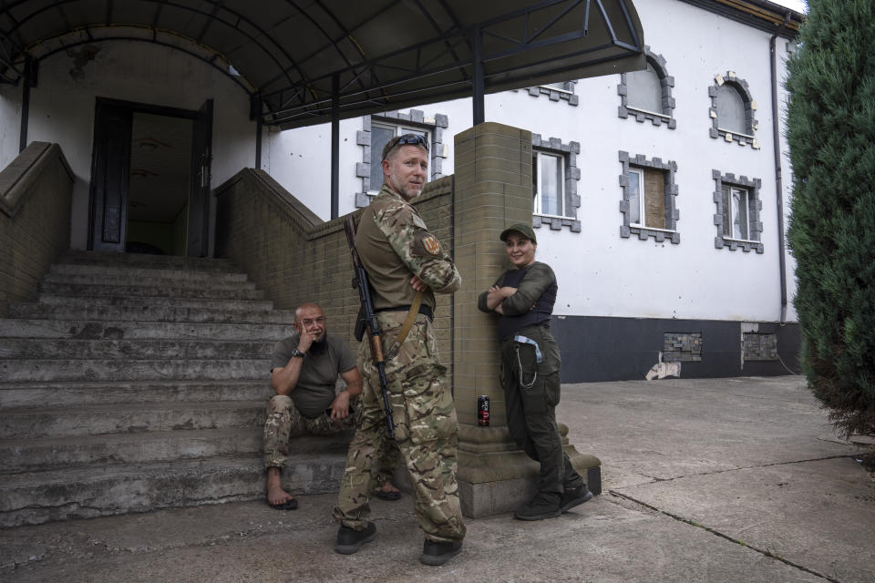 Former Muslim Mufti-turned-fighter Sheikh Said Ismahilov, center, speaks with Muslim paramedic Olga Bashei, right, Imam Haji Murad, left, after prayers on the first day of Eid al-Adha, in Medina Mosque, Konstantinovka, eastern Ukraine, Saturday, July 9, 2022. (AP Photo/Nariman El-Mofty)