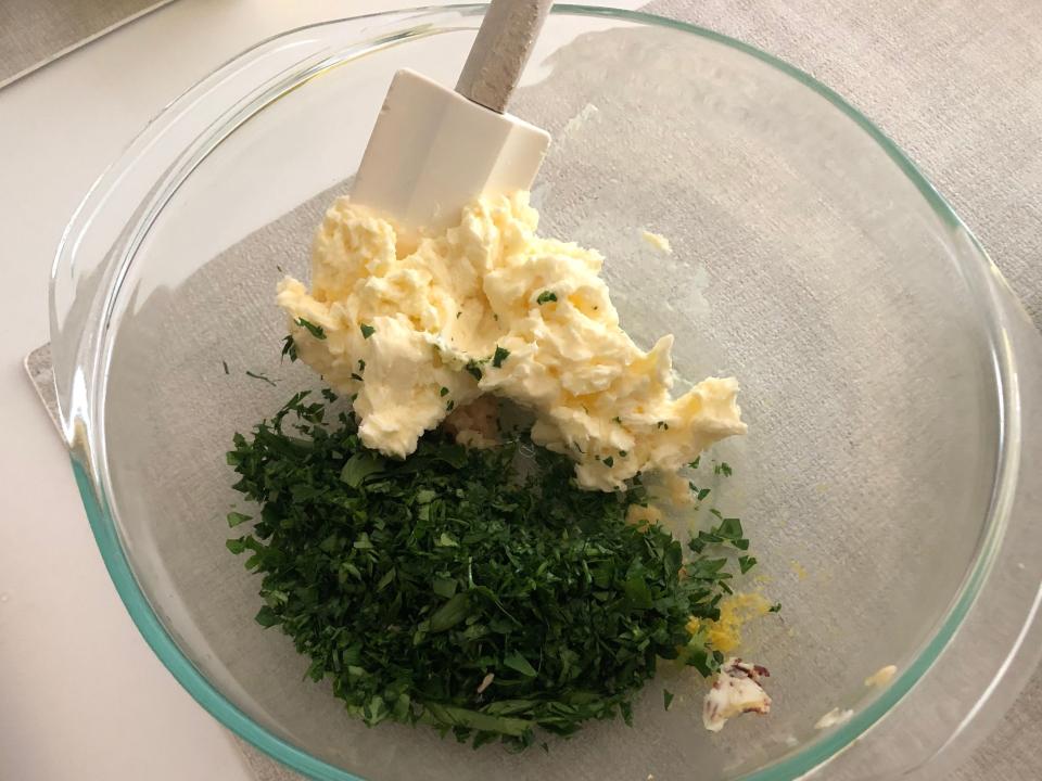 Herbs mixed into bowl of butter.