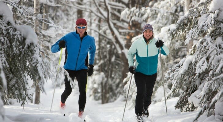 A couple cross-country skiing through a wooded snowscape in Michigan.