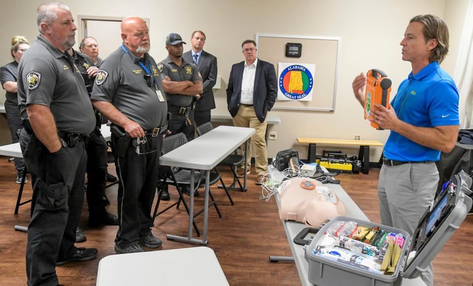 Law enforcement officials watch as Rob Williams, right, demonstrates the use of an AED device Thursday in Prattville.
