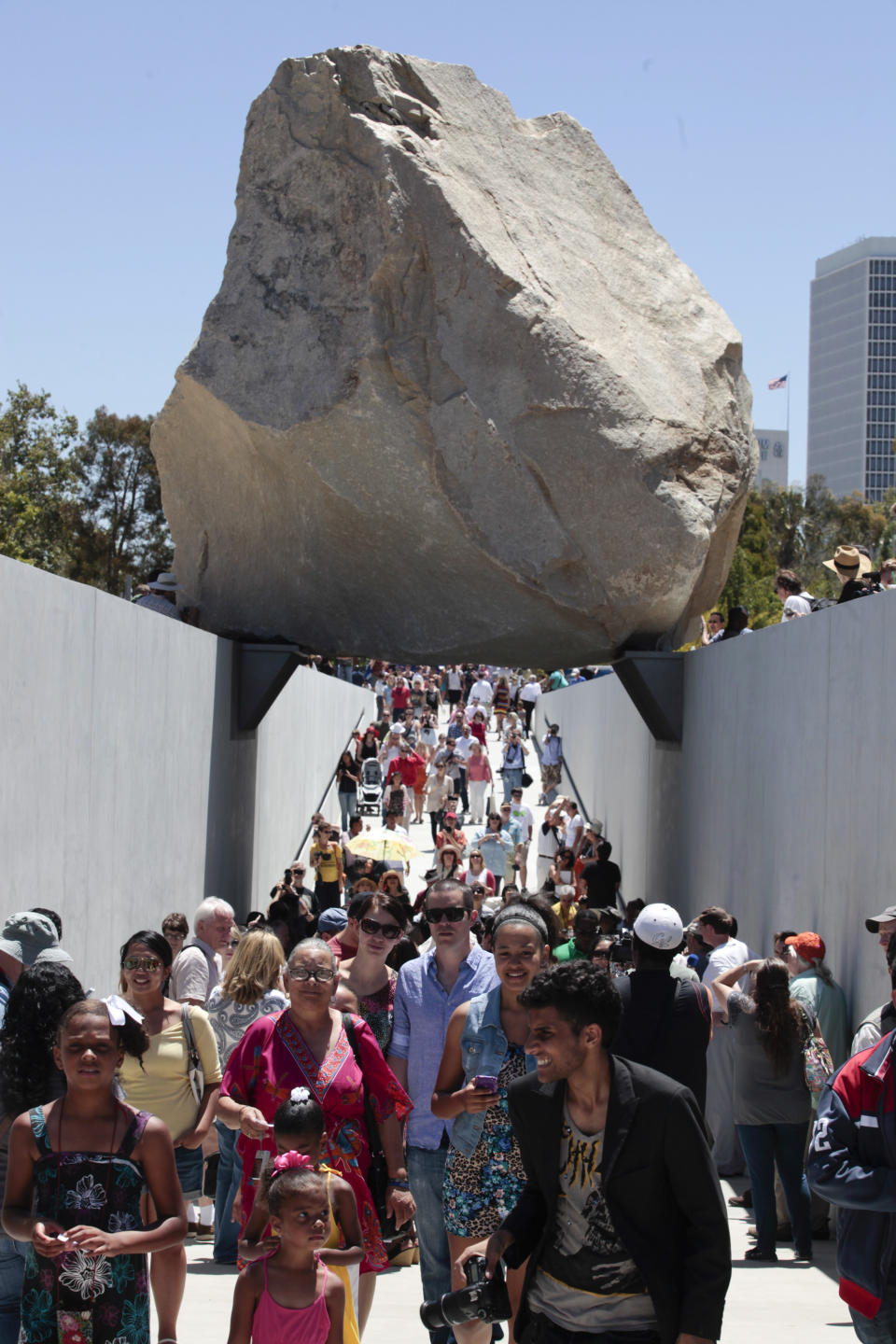 Visitors view Michael Heizer’s "Levitated Mass" at the Los Angeles County Museum of Art in Los Angeles, on Sunday June 24,2012. Thousands showed up as the gigantic work was unveiled on the museum’s rear lawn, where it is intended to remain forever. (AP Photo/Richard Vogel)