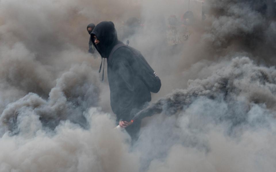 A protester stands amid tear gas during a demonstration to protest against French government's string of labour reforms - www.alamy.com