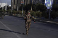 An Afghan security forces works at the site where a bus carrying local TV station employees hit a roadside bomb in Kabul, Afghanistan, Saturday, May 30, 2020. (AP Photo/Rahmat Gul)