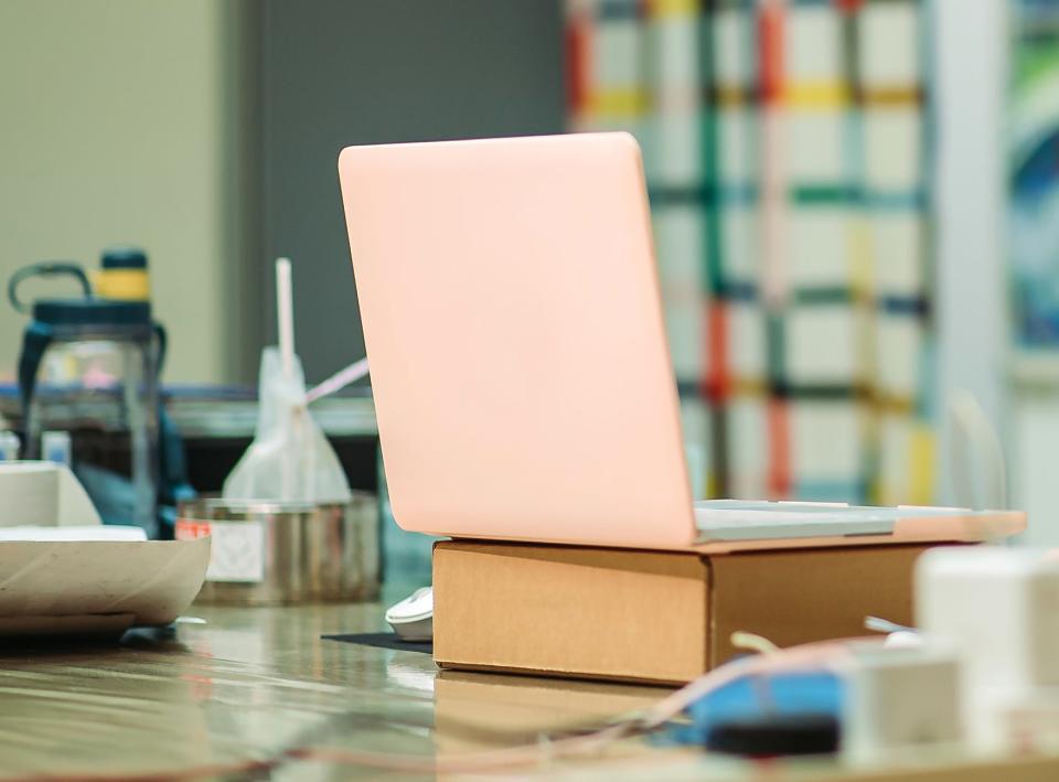 laptop on top of box on teacher's desk