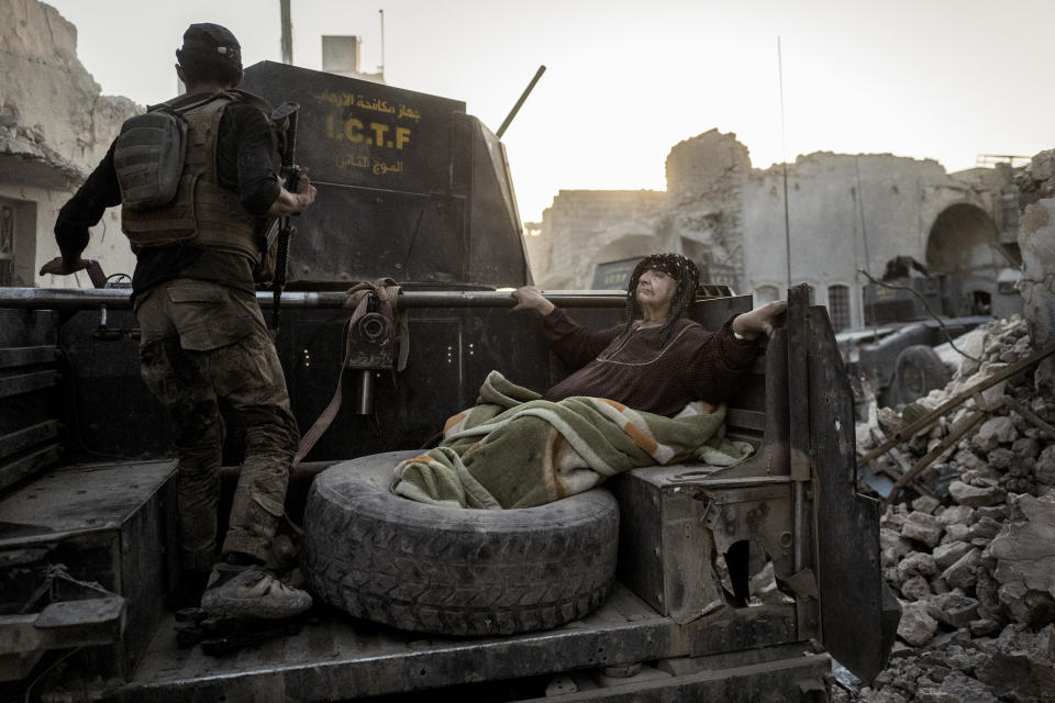 An elderly woman is driven through the city on the back of one of Golden Division&rsquo;s Humvees. The temperature is nearly 50 degrees Celcius, and she&rsquo;s too weak to get away from the frontline on her own.