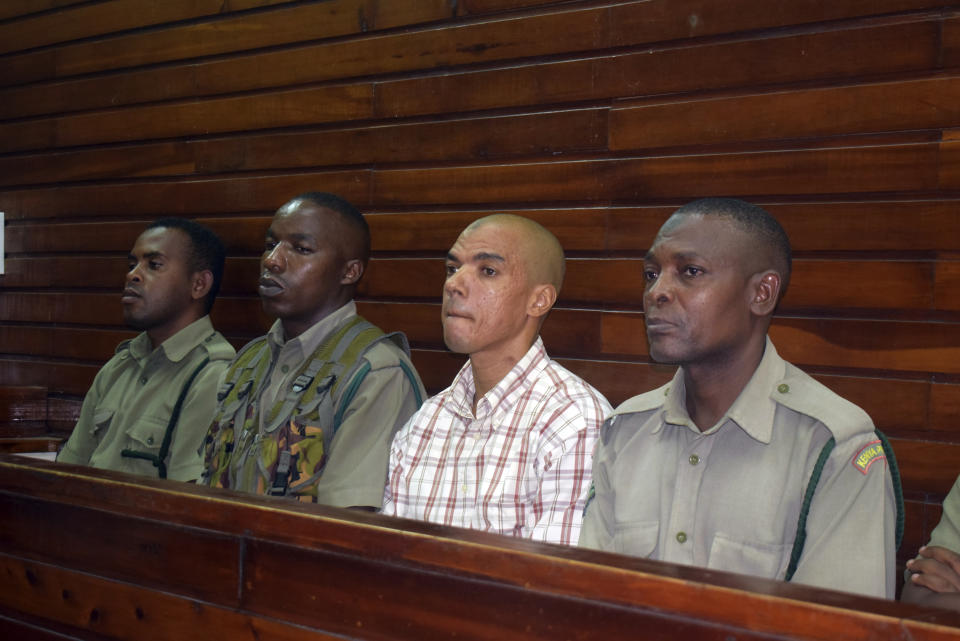 Guarded by heavy security, British suspect Jermaine Grant, second right, sits in a Mombasa court awaiting sentencing, in Mombasa, Kenya, Thursday, May 9, 2019, A Kenyan court has jailed a British national believed to be part of an extremist cell to four years in prison for possession of bomb making material. (AP Photo)
