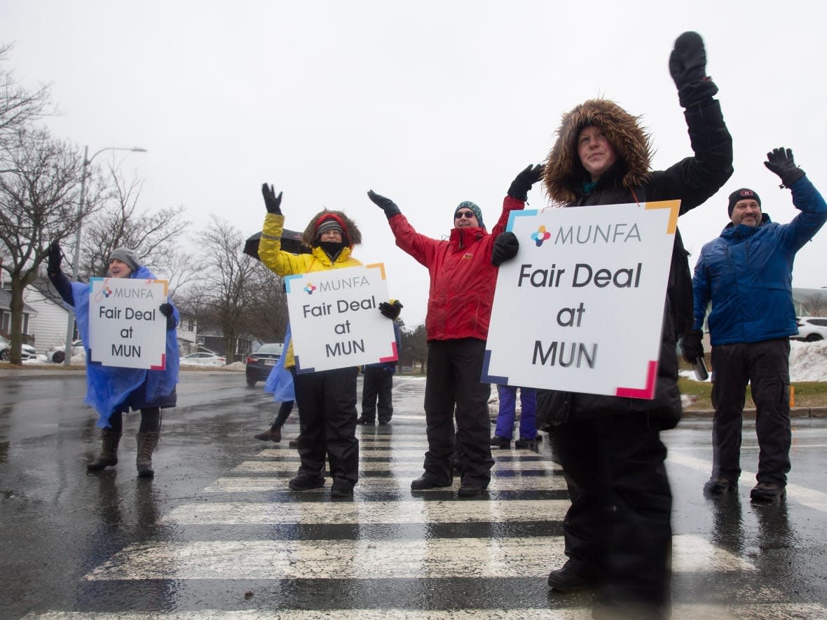 Members of Memorial University Faculty Association wave to supporters as they man a picket line.  (Paul Daly/The Canadian Press - image credit)