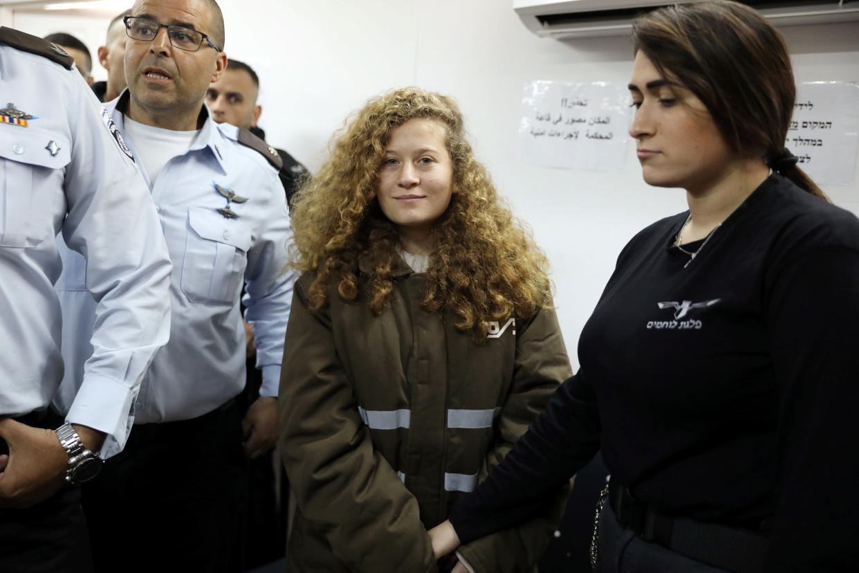 Palestinian teen Ahed Tamimi enters a military courtroom escorted by Israeli security personnel at Ofer Prison, near the West Bank city of Ramallah, Jan. 15, 2018. (Photo: Ammar Awad/Reuters)