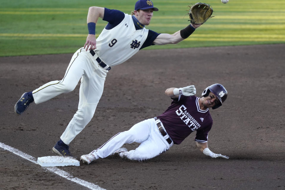 Notre Dame infielder Jack Brannigan (9) moves toward the ball as Mississippi State's Scott Dubrule, bottom, safely steals third base at an NCAA college baseball super regional game, Monday, June 14, 2021, in Starkville, Miss. (AP Photo/Rogelio V. Solis)