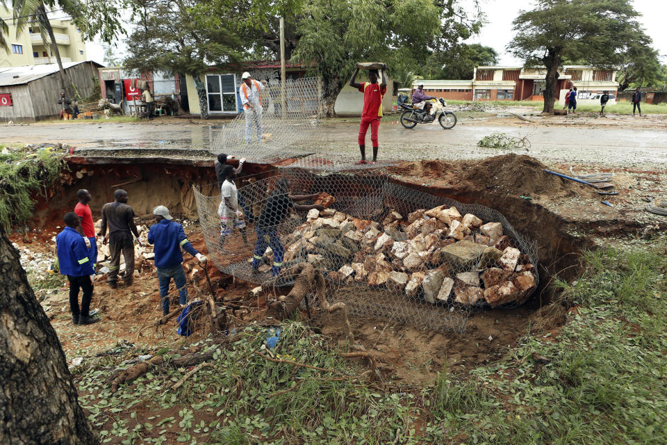 Men repair a road damaged by Cyclone Kenneth in Pemba city on the northeastern coast of Mozambique, Saturday, April, 27, 2019. Cyclone Kenneth arrived late Thursday, just six weeks after Cyclone Idai ripped into central Mozambique and killed more than 600 people.At least four deaths have been reported in the city and another in hard hit Macomia district, while residents on Ibo Island say two people have died there.(AP Photo/Tsvangirayi Mukwazhi)