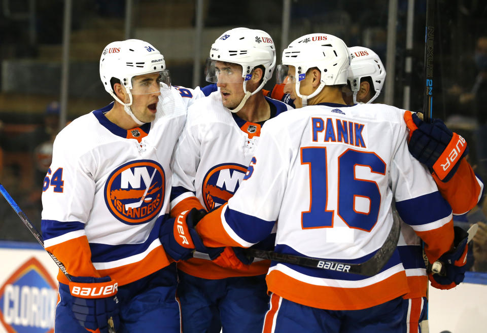 New York Islanders center Brock Nelson (29) celebrates with teammates Erik Gustafsson (64) and Richard Panik (16) after scoring a goal against the New York Rangers during the first period of a preseason NHL hockey game, Sunday, Sept. 26, 2021, in New York. (AP Photo/Noah K. Murray)