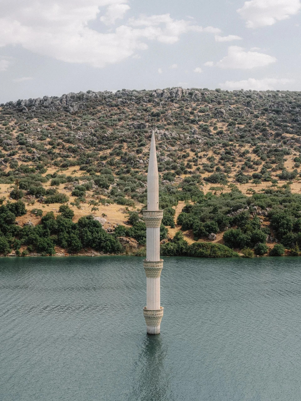 The minaret of a sunken mosque emerges from the reservoir of the Birecik dam in Gaziantep. For several decades now, dozens of villages and towns have disappeared under water as a result of the numerous hydroelectric power plant projects of successive governments under the Southeast Anatolia Project (Emin Ozmen/Magnum Photos)