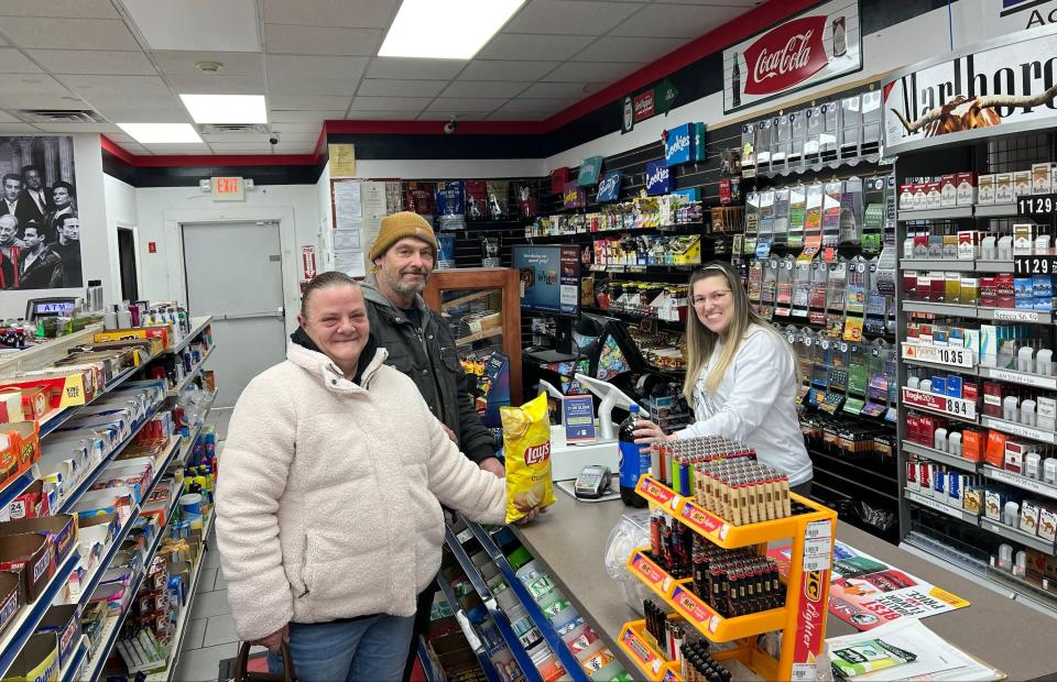 Dave's Fast Mart cashier Eulalia Cordeiro processes a grocery purchase from Dighton residents Gary and Michelle Humann on Feb. 27