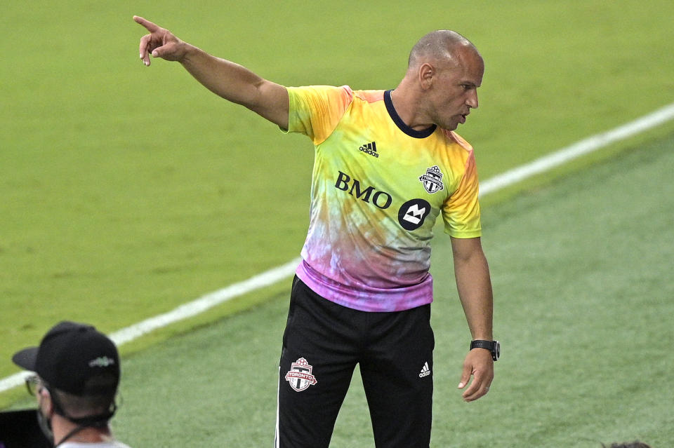 Toronto FC head coach Chris Armas talks to his staff in front of the bench during the first half of an MLS soccer match against FC Cincinnati, Saturday, June 26, 2021, in Orlando, Fla. (AP Photo/Phelan M. Ebenhack)