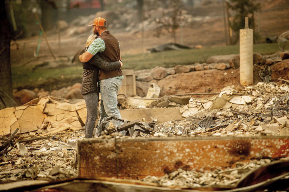 Chris and Nancy Brown embrace while searching through the remains of their home in Paradise, California (Picture: AP)