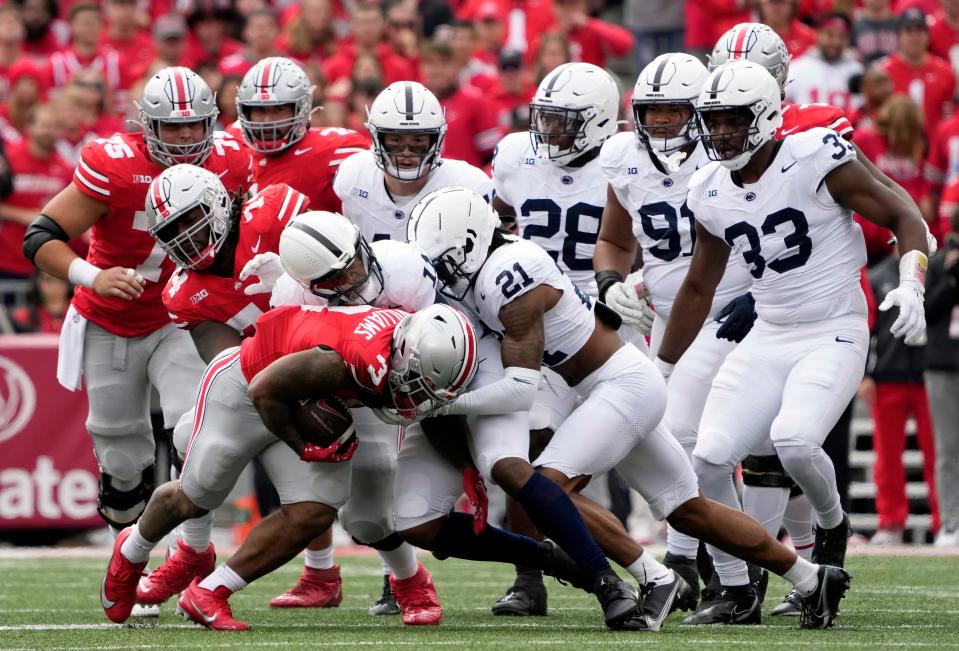 Ohio State running back Miyan Williams s stopped by Penn State's Abdul Carter (11) and Kevin Winston Jr. (21).