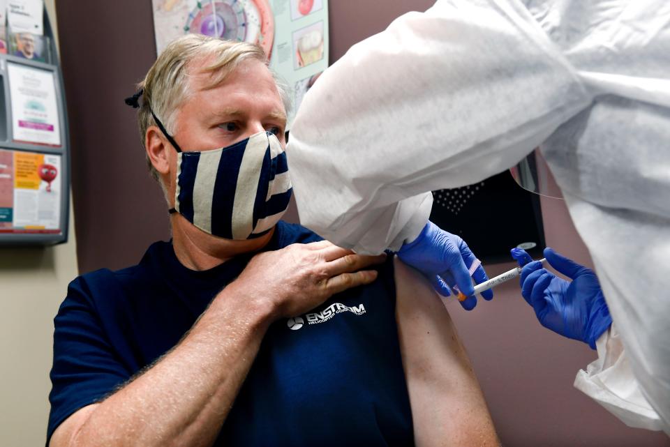 Nurse Carolyn Grausgruber gives volunteer Ithaca firefighter Wade Bardo, of Erin, N.Y., an injection as the world's biggest study of a possible COVID-19 vaccine, developed by the National Institutes of Health and Moderna Inc., gets underway July 27, 2020, in Binghamton, N.Y.